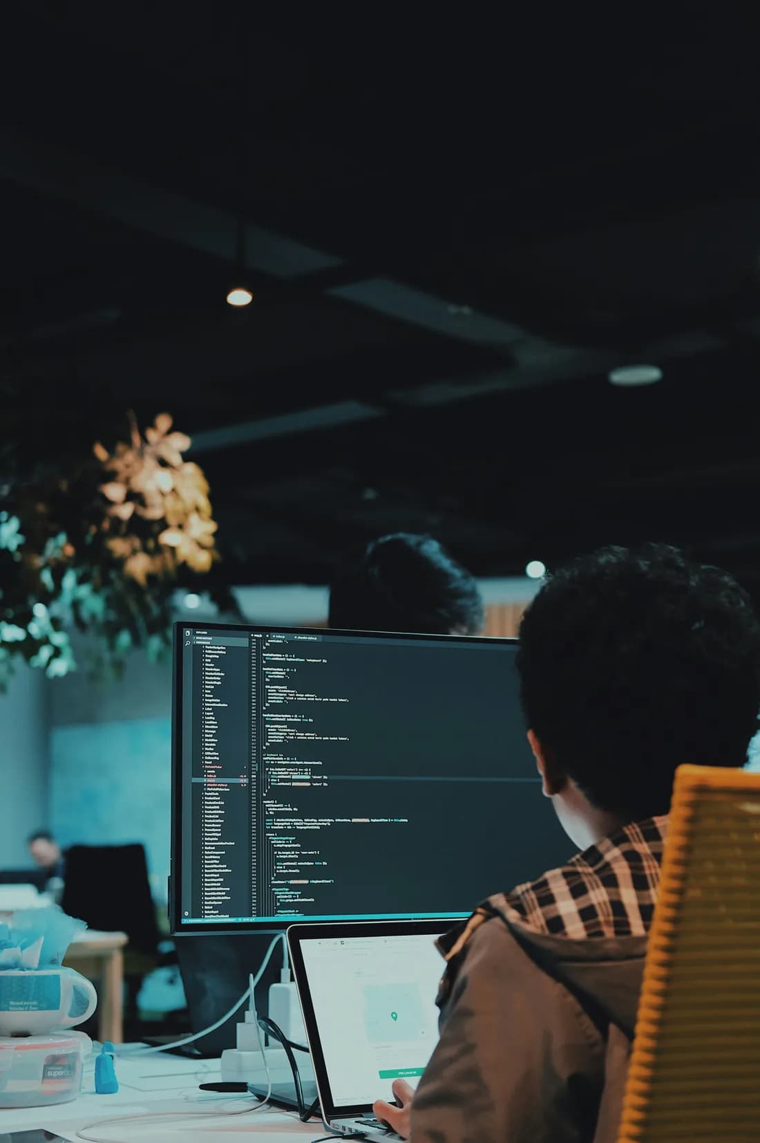 A Motion Devs engineer reviewing code on a widescreen monitor in the Nairobi office.